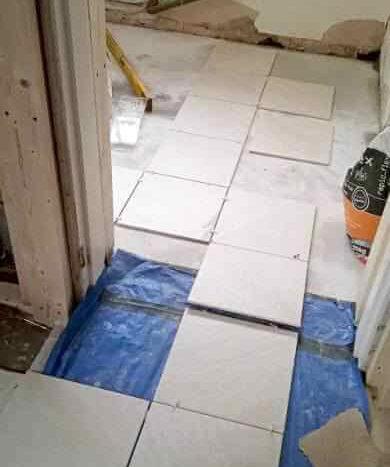 setting out the layout for the tiles between the WC and kitchen area