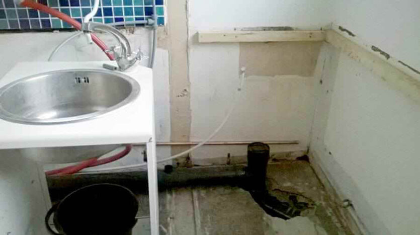stud wall removed between old kitchen and WC with new soil pipe installed and temporary sink in new kitchen area