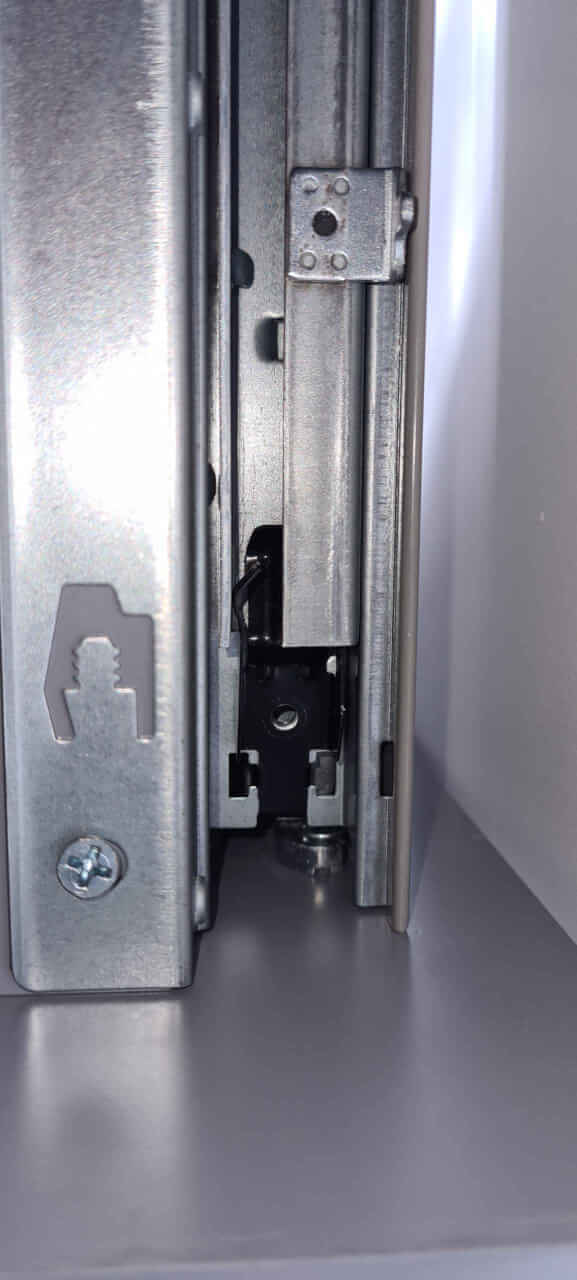 Drawer rail spring clip inserted with tang in housing before having the screw inserted.