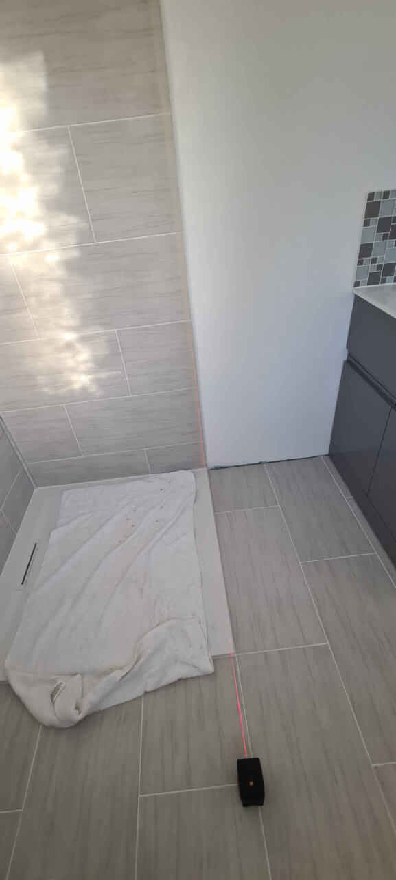 Using laser level to mark out position of shower enclosure glass panel