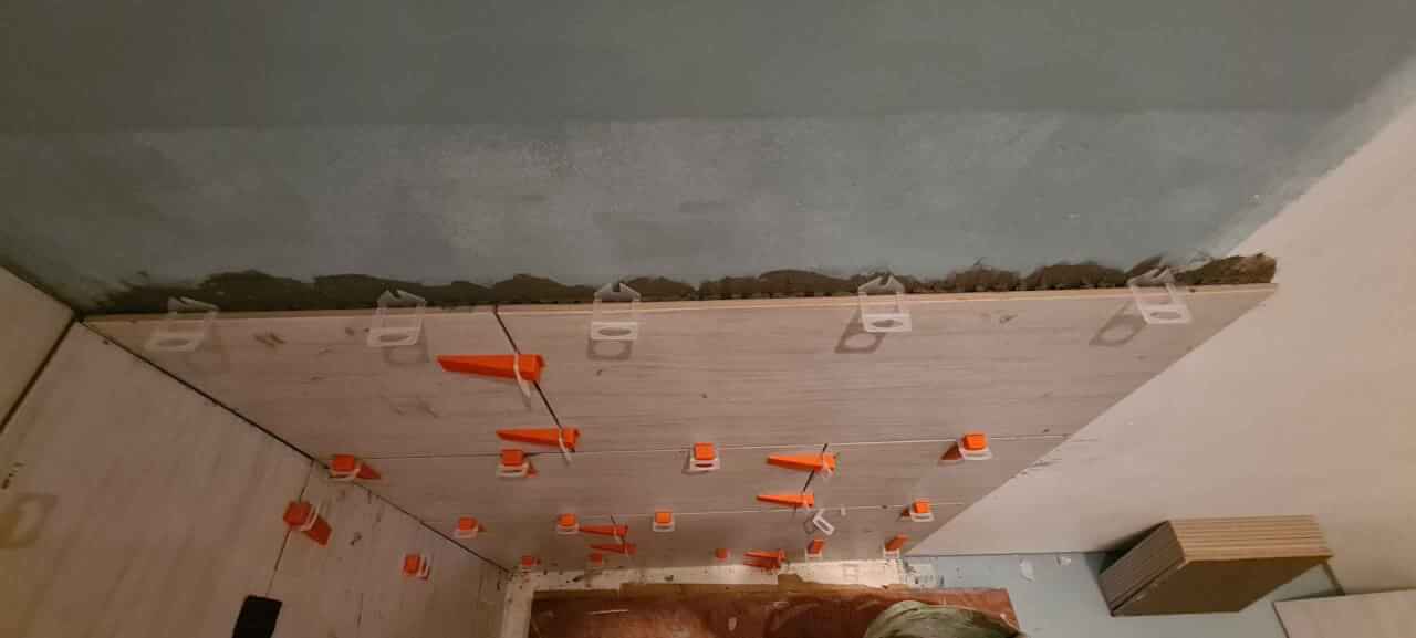 Wall tiles fixed using levelling system spacers and wedges