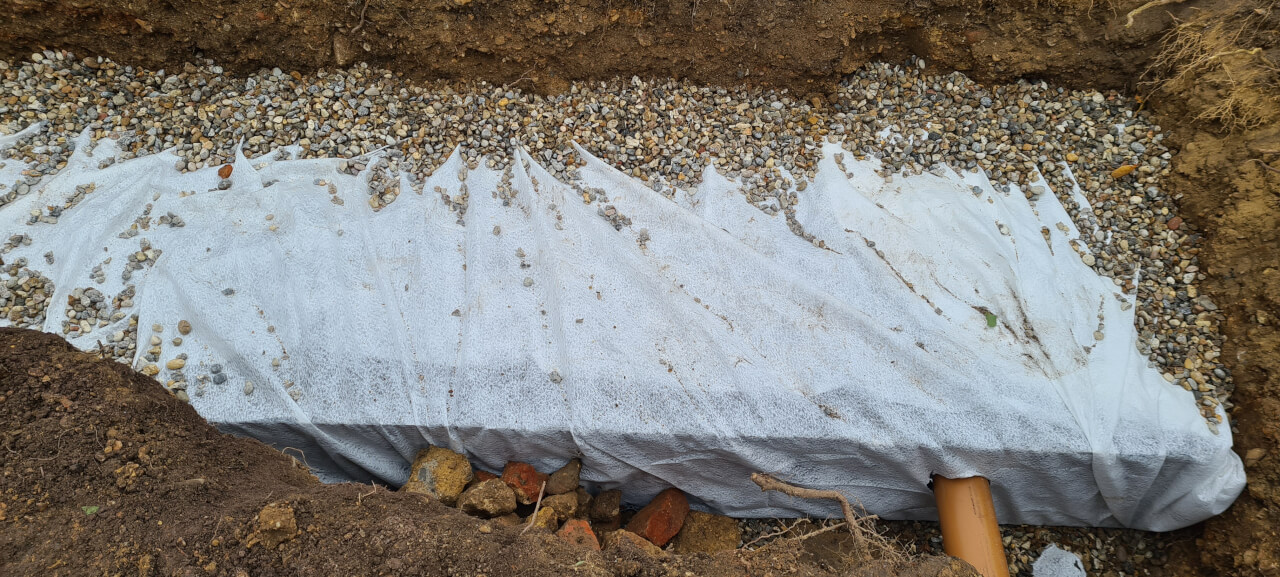 Gravel lining the soak away pit and covering terram