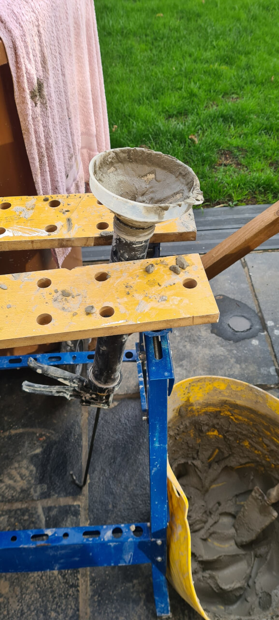 Trowling the gunnable mortar into the grout gun using a cutdown funnel