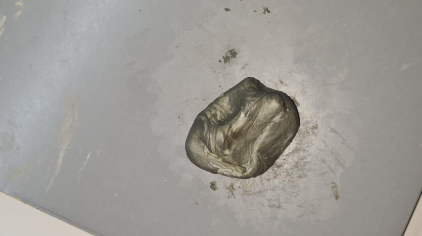 Two part epoxy being kneaded into uniform grey colour scaled e1674037497386