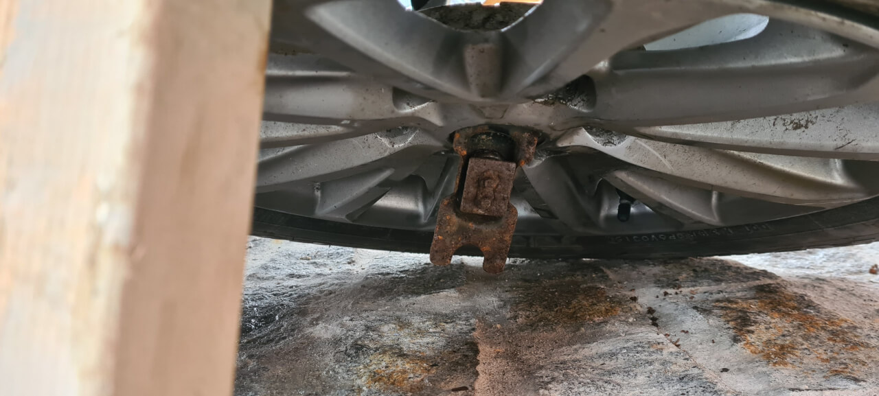 Poking the winch chain securing plate through the wheel center cap hole
