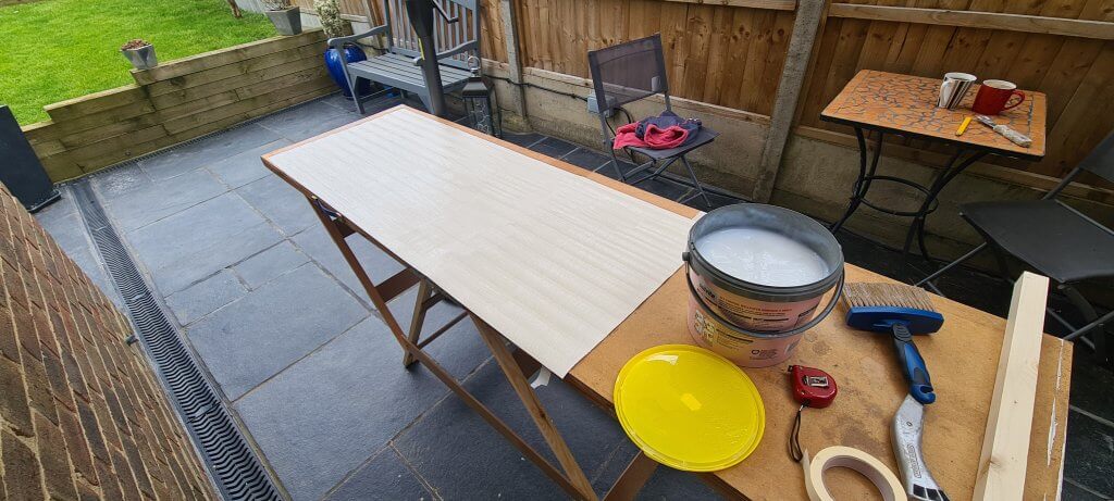 Cutting and pasting the wallpaper on a pasting trestle table